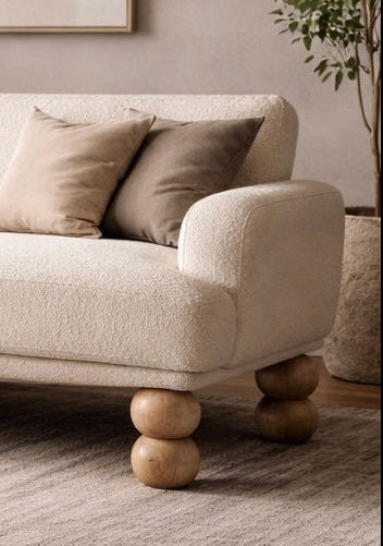 Beige sofa with wooden legs in a living room setting