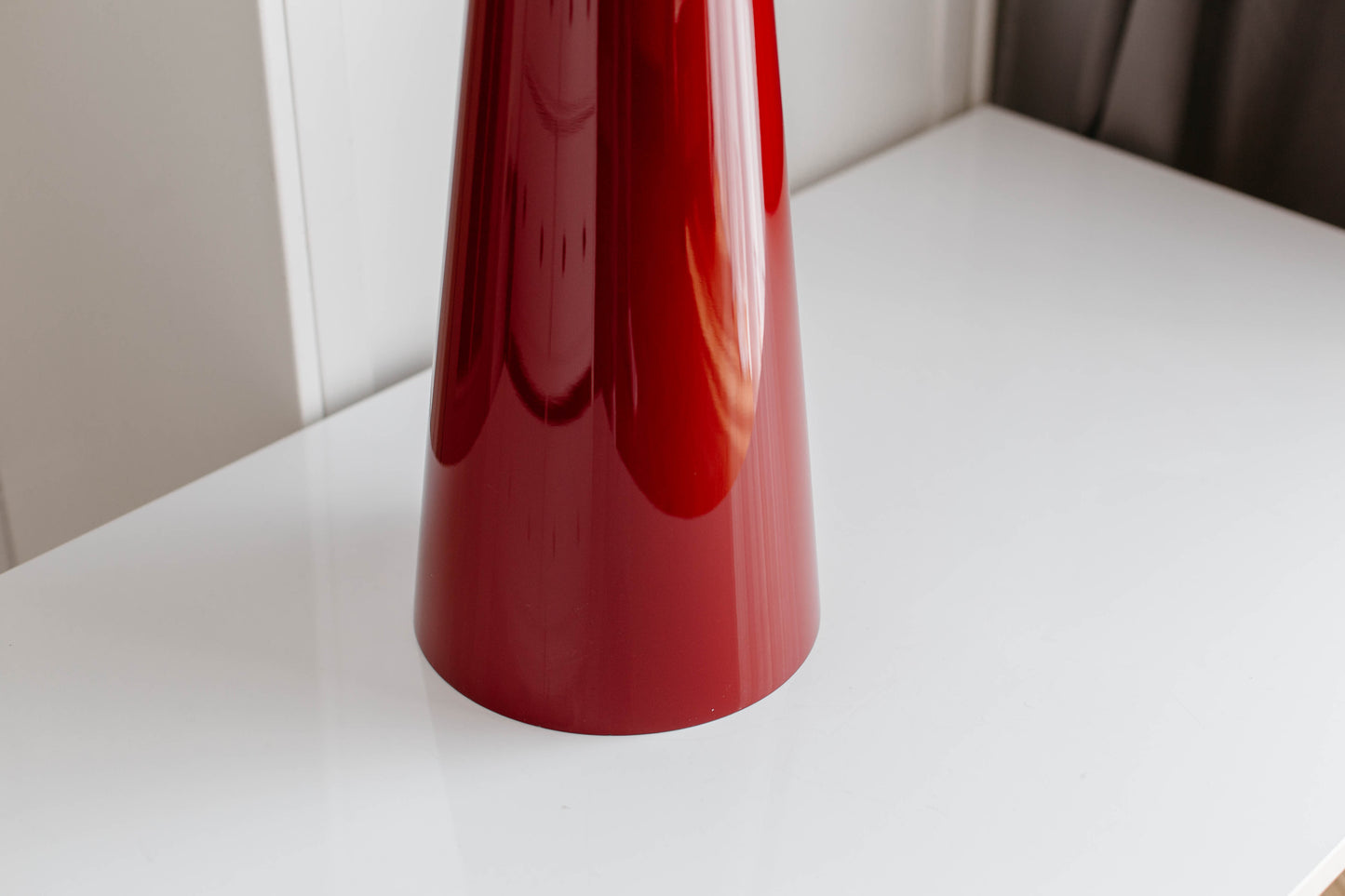 Red cylindrical object on a white surface