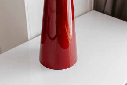 Red cylindrical object on a white surface